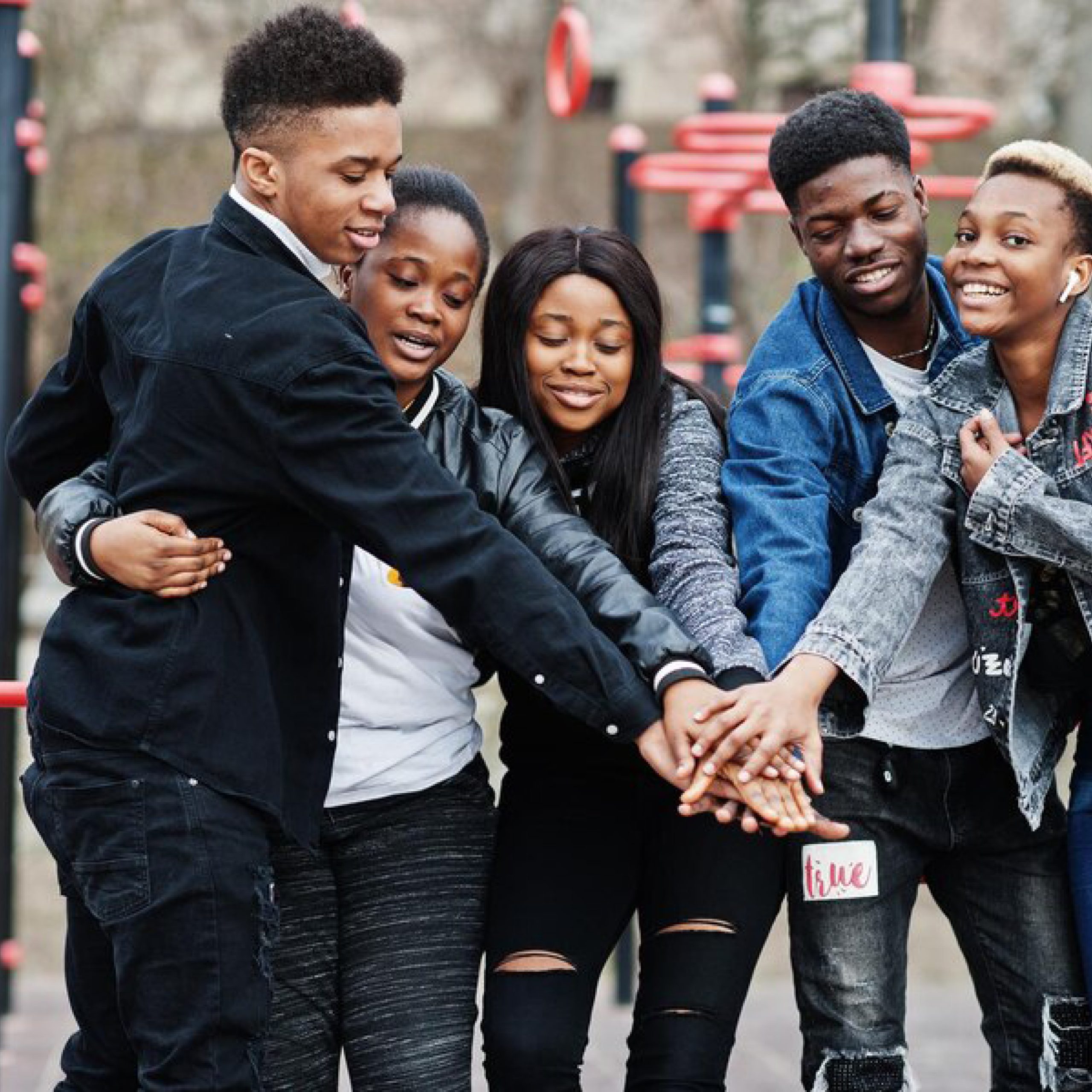 Young people with hands together.